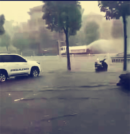 风雨中洒水车辛勤工作