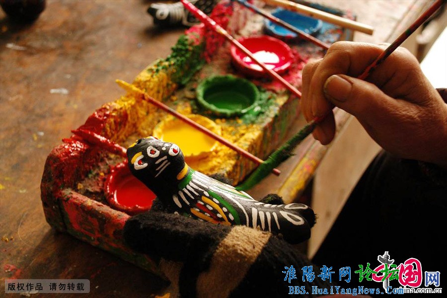 “泥泥狗”是用胶泥捏制而成，全身染黑色作底，然后用大红、黄、白、绿、桃红五色点画。中国网图片库 杨正华/摄